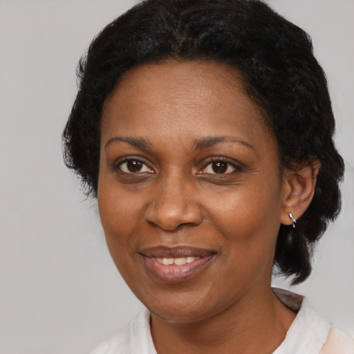 Joyful black adult female with short  black hair and brown eyes