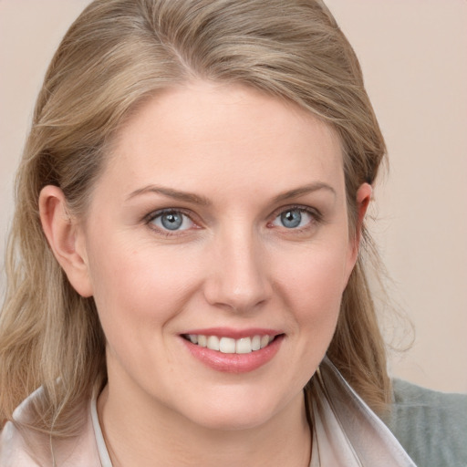 Joyful white young-adult female with long  blond hair and blue eyes