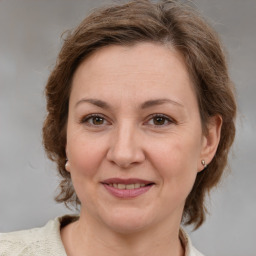 Joyful white adult female with medium  brown hair and grey eyes