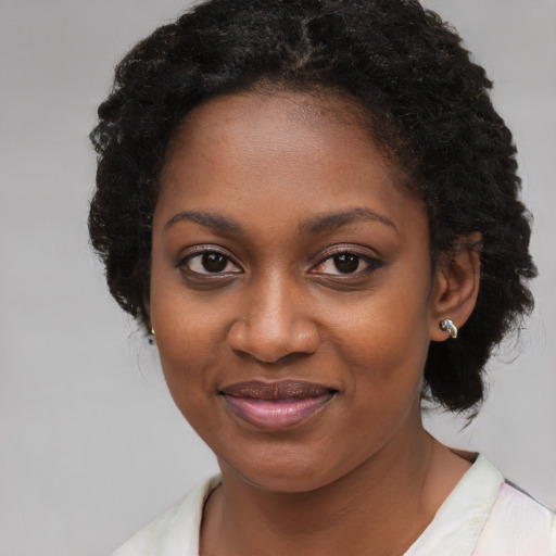Joyful black young-adult female with long  brown hair and brown eyes