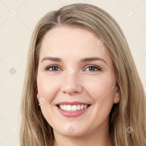 Joyful white young-adult female with long  brown hair and green eyes