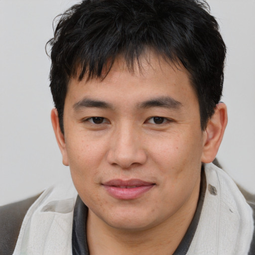 Joyful asian young-adult male with short  brown hair and brown eyes