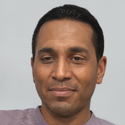 Joyful latino adult male with short  black hair and brown eyes