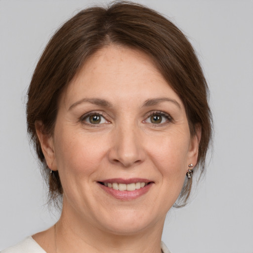 Joyful white adult female with medium  brown hair and grey eyes