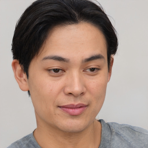 Joyful asian young-adult male with short  brown hair and brown eyes