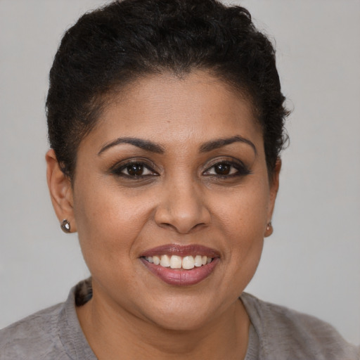 Joyful black young-adult female with short  brown hair and brown eyes