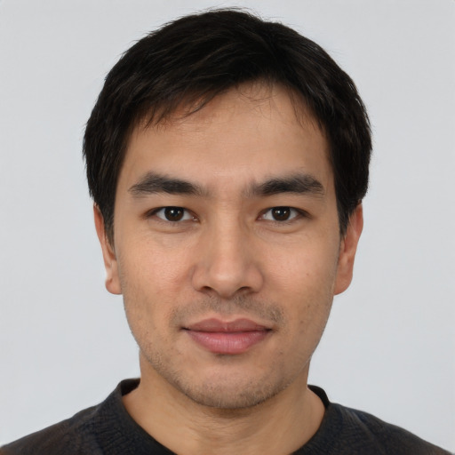Joyful asian young-adult male with short  black hair and brown eyes