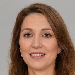 Joyful white adult female with long  brown hair and green eyes