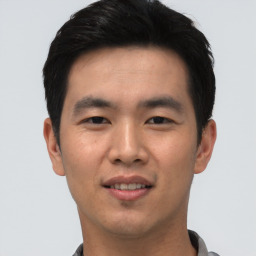 Joyful asian young-adult male with short  black hair and brown eyes