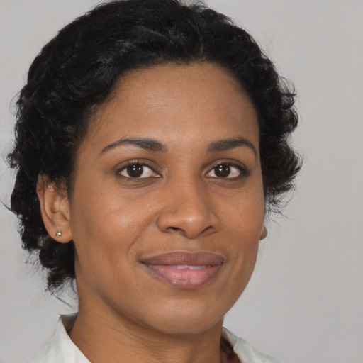 Joyful black adult female with short  brown hair and brown eyes