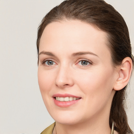 Joyful white young-adult female with medium  brown hair and grey eyes