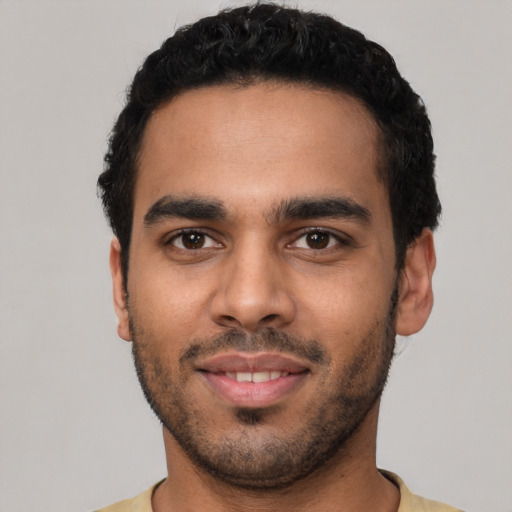 Joyful latino young-adult male with short  black hair and brown eyes