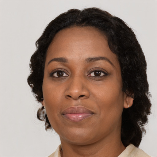 Joyful black adult female with medium  brown hair and brown eyes