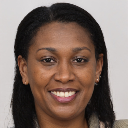 Joyful black adult female with long  brown hair and brown eyes