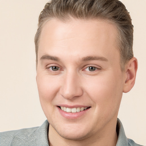 Joyful white young-adult male with short  brown hair and grey eyes