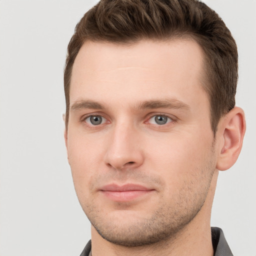 Joyful white young-adult male with short  brown hair and grey eyes