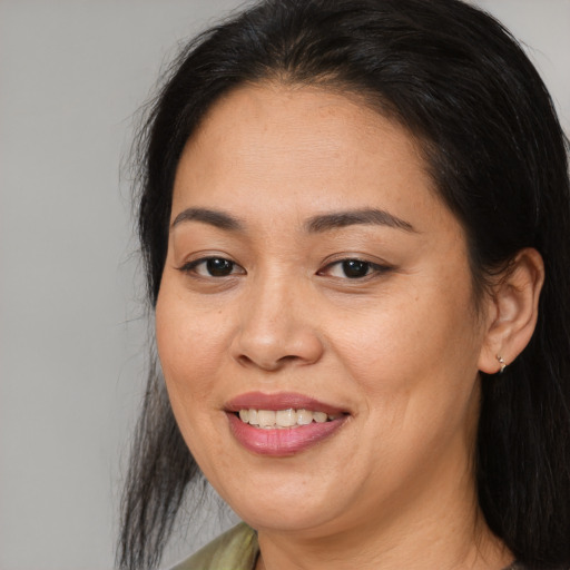 Joyful latino adult female with long  brown hair and brown eyes