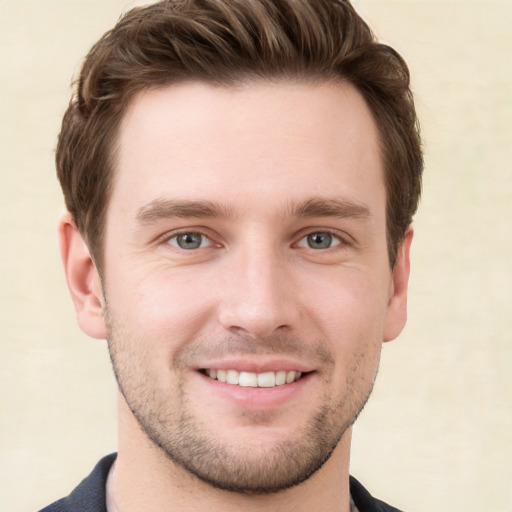 Joyful white young-adult male with short  brown hair and grey eyes