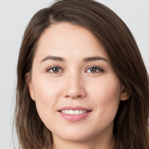 Joyful white young-adult female with long  brown hair and brown eyes