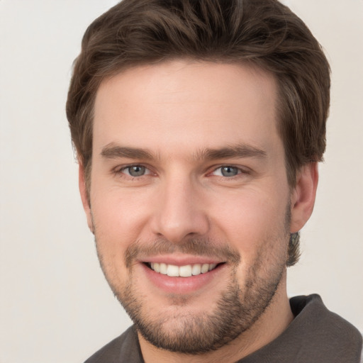 Joyful white young-adult male with short  brown hair and grey eyes