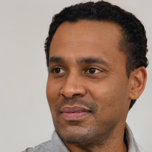 Joyful black young-adult male with short  black hair and brown eyes
