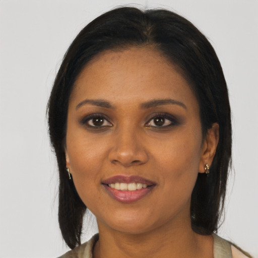Joyful black young-adult female with long  brown hair and brown eyes