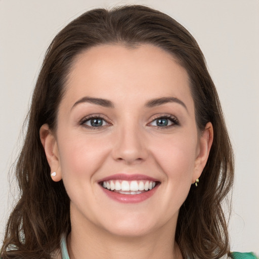 Joyful white young-adult female with long  brown hair and green eyes