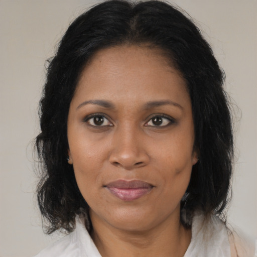 Joyful black adult female with medium  brown hair and brown eyes