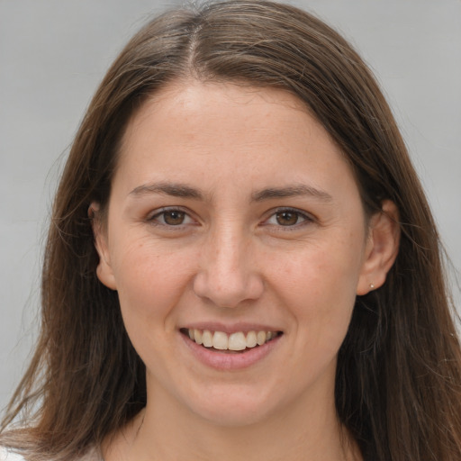 Joyful white young-adult female with long  brown hair and brown eyes