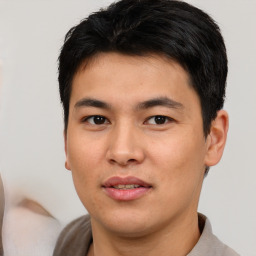 Joyful asian young-adult male with short  black hair and brown eyes