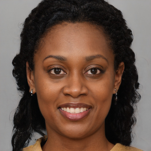 Joyful black young-adult female with medium  brown hair and brown eyes