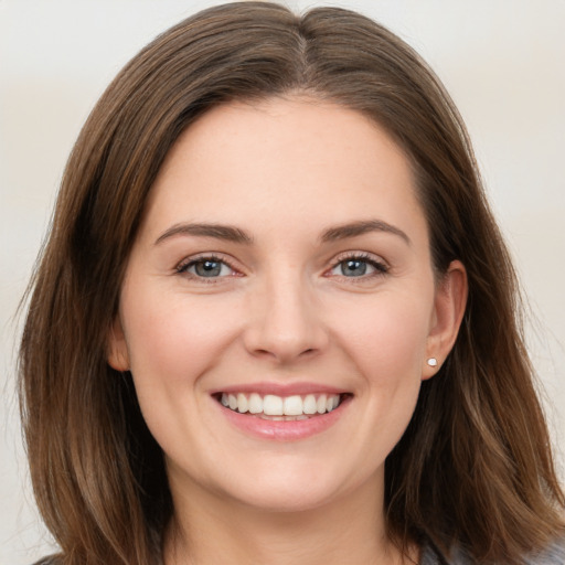 Joyful white young-adult female with long  brown hair and grey eyes