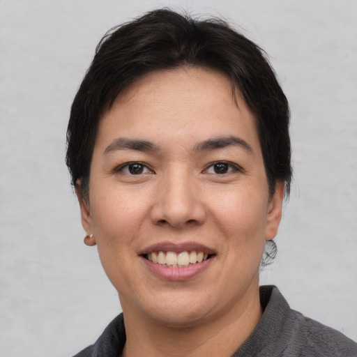 Joyful asian young-adult female with short  brown hair and brown eyes