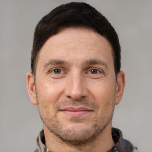 Joyful white adult male with short  brown hair and brown eyes