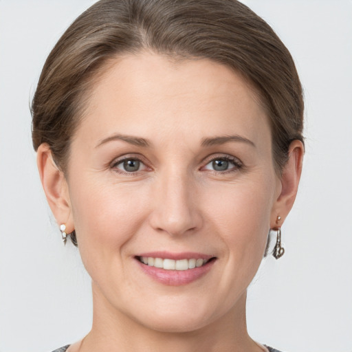 Joyful white young-adult female with short  brown hair and grey eyes