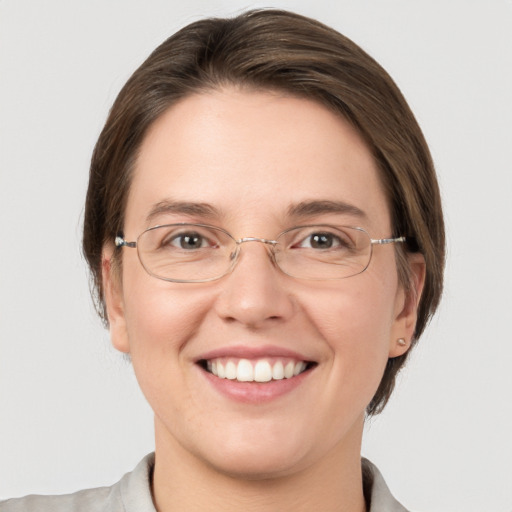 Joyful white young-adult female with medium  brown hair and grey eyes