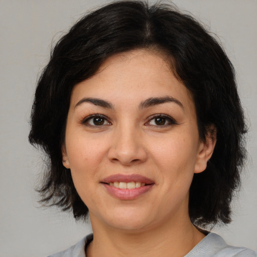 Joyful latino young-adult female with medium  brown hair and brown eyes