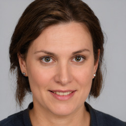 Joyful white adult female with medium  brown hair and grey eyes