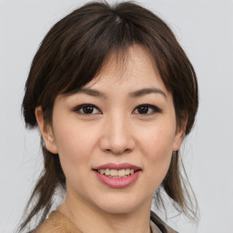 Joyful asian young-adult female with medium  brown hair and brown eyes