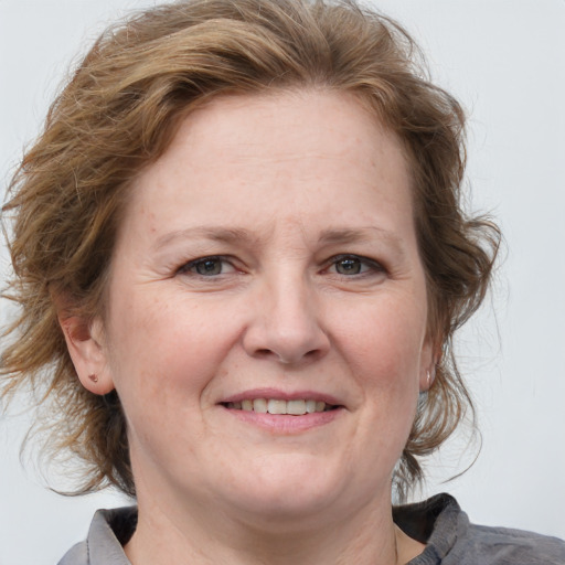 Joyful white adult female with medium  brown hair and blue eyes