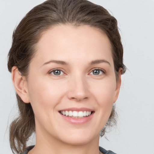 Joyful white young-adult female with medium  brown hair and grey eyes