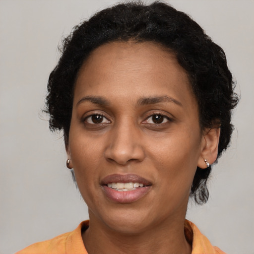 Joyful black adult female with short  black hair and brown eyes