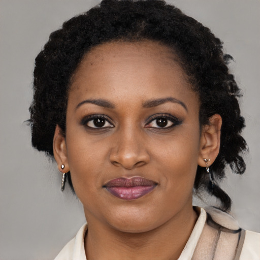 Joyful black young-adult female with long  brown hair and brown eyes