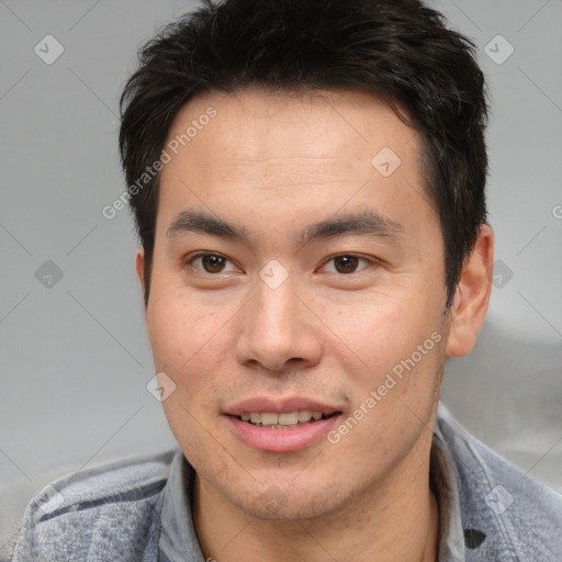 Joyful asian young-adult male with short  brown hair and brown eyes