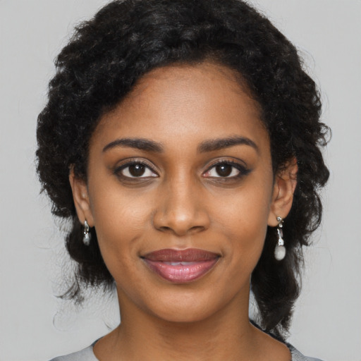 Joyful black young-adult female with long  black hair and brown eyes
