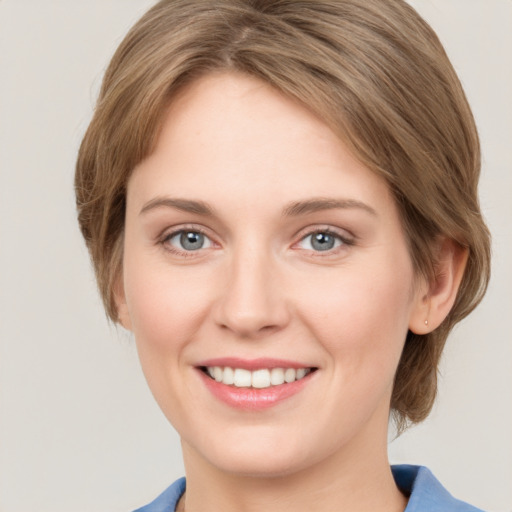 Joyful white young-adult female with medium  brown hair and grey eyes