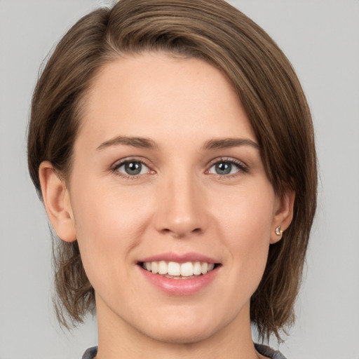 Joyful white young-adult female with medium  brown hair and grey eyes