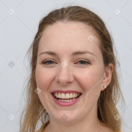 Joyful white adult female with long  brown hair and grey eyes