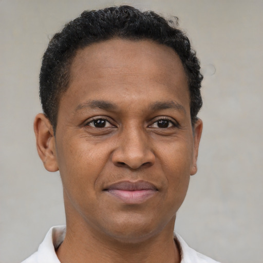 Joyful black young-adult male with short  brown hair and brown eyes