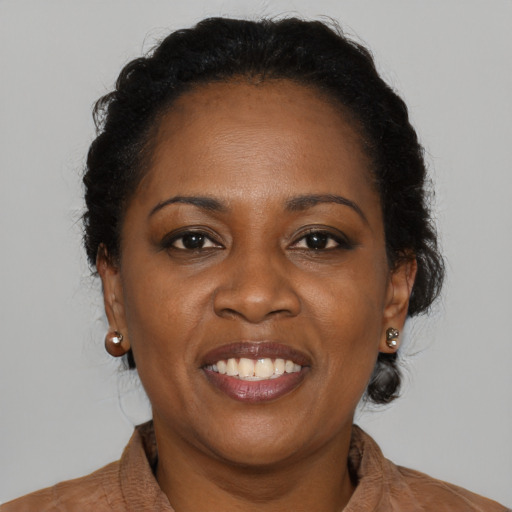 Joyful black adult female with medium  brown hair and brown eyes